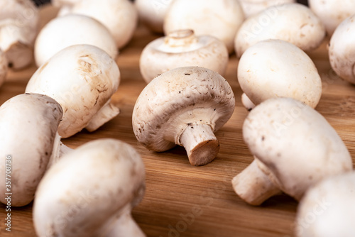 Selective focus Fresh champignon mushrooms on a wooden background.