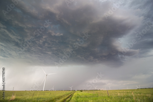Canvas-taulu The dark base of a supercell thunderstorm over wind turbines in the prairie