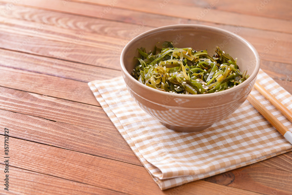 Bowl with tasty seaweed on wooden background Bowl with tasty seaweed on wooden background