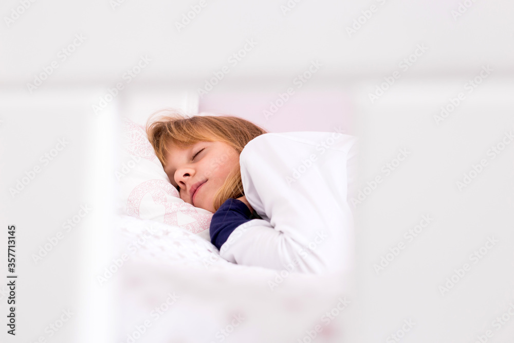 Cute little, blond girl sleeping. Morning time, surrounded with white Cute little, blond girl sleeping. Morning time, surrounded with white