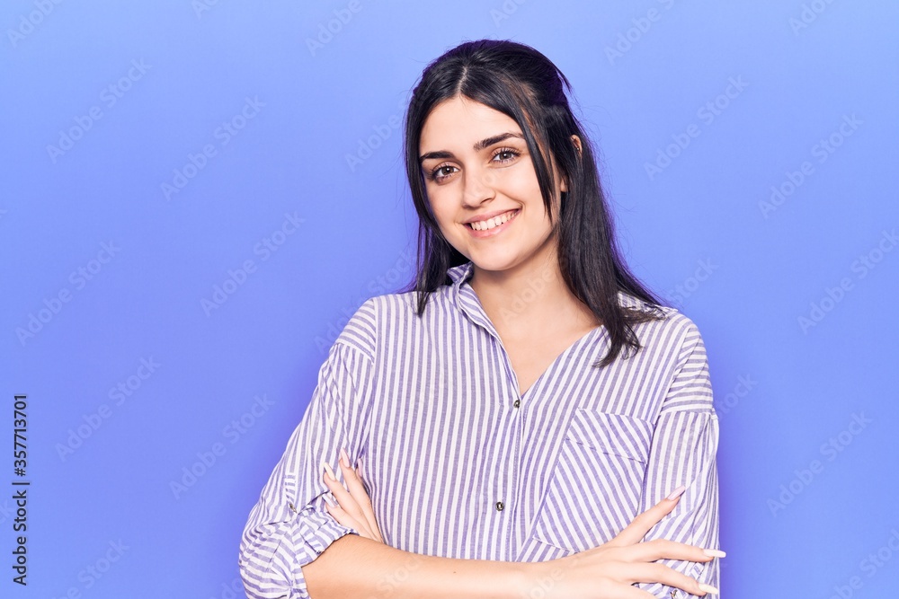 Young beautiful girl wearing casual striped shirt happy face smiling with crossed arms looking at the camera. positive person. Young beautiful girl wearing casual striped shirt happy face smiling with crossed arms looking at the camera. positive person.