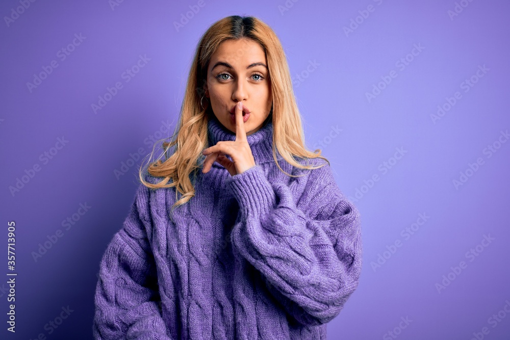 Young beautiful blonde woman wearing casual turtleneck sweater over purple background asking to be quiet with finger on lips. Silence and secret concept.