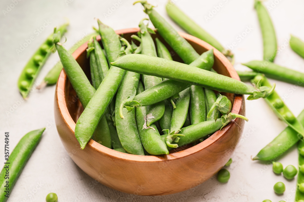 Bowl with tasty fresh peas on light background Bowl with tasty fresh peas on light background