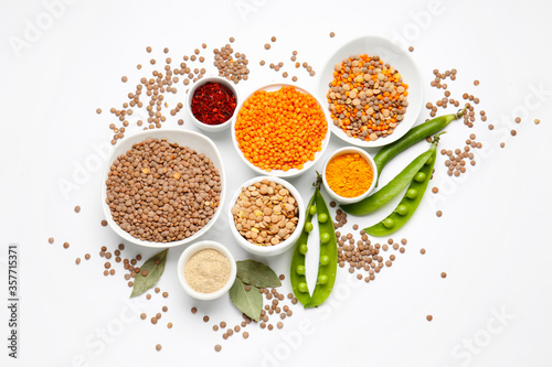 Bowls with lentils and spices on white background