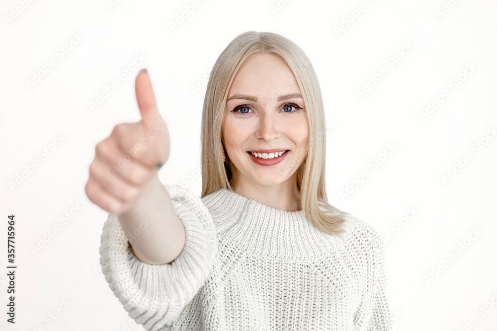 young happy blonde girl shows like gesture on white background young happy blonde girl shows like gesture on white background