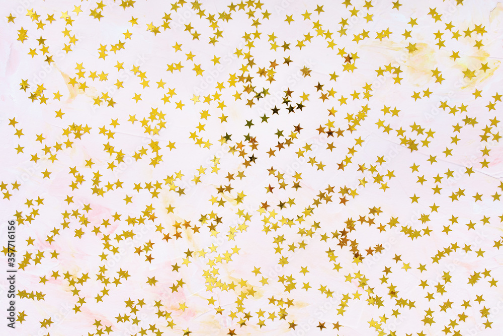 Trendy golden foil confetti stars on pink background. Christmas festive abstract backround. Birthday party, New Year, Christmas celebration, holidays, winter and dreams concept