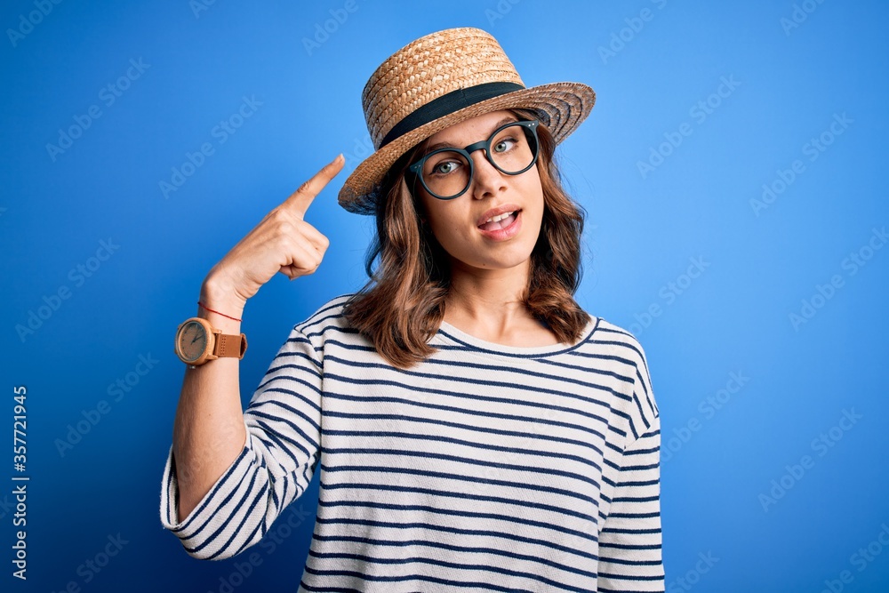 Young beautiful blonde girl wearing glasses and hat over blue isolated background very happy pointing with hand and finger Young beautiful blonde girl wearing glasses and hat over blue isolated background very happy pointing with hand and finger