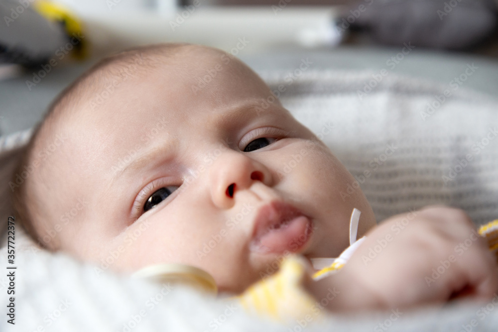 A close-up portrait of a newborn baby girl who drooling. three-month-old baby lies in a cradle and reskeries milk A close-up portrait of a newborn baby girl who drooling. three-month-old baby lies in a cradle and reskeries milk