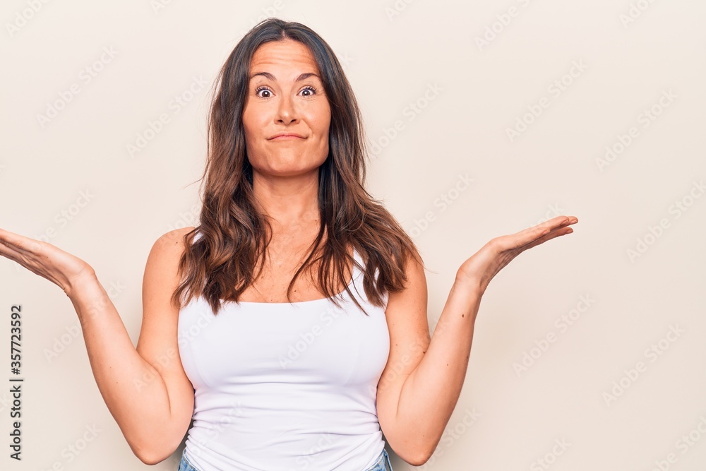 Young beautiful brunette woman wearing casual t-shirt standing over isolated white background smiling with happy face winking at the camera doing victory sign. Number two. Young beautiful brunette woman wearing casual t-shirt standing over isolated white background smiling with happy face winking at the camera doing victory sign. Number two.