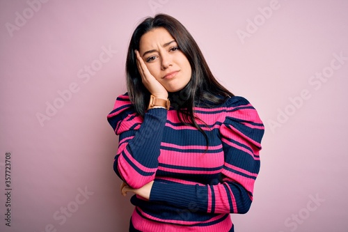 Young brunette elegant woman wearing striped shirt over pink isolated background thinking looking tired and bored with depression problems with crossed arms.