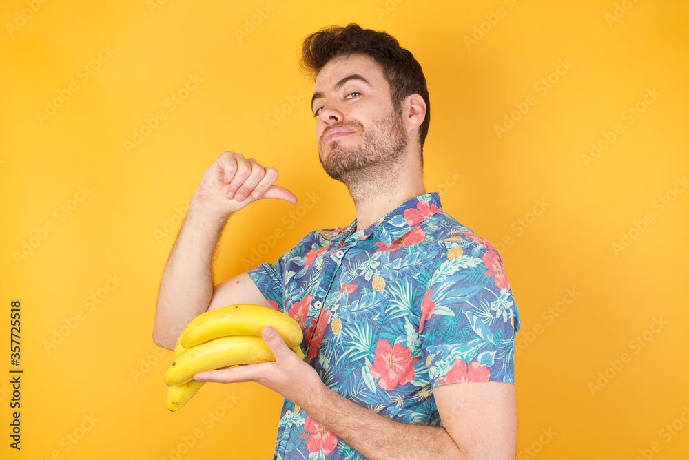 Φωτογραφία Closeup of cheerful handsome European dark haired blue eyed man looks joyful, satisfied and confident, points at himself with thumb, isolated over gray studio background