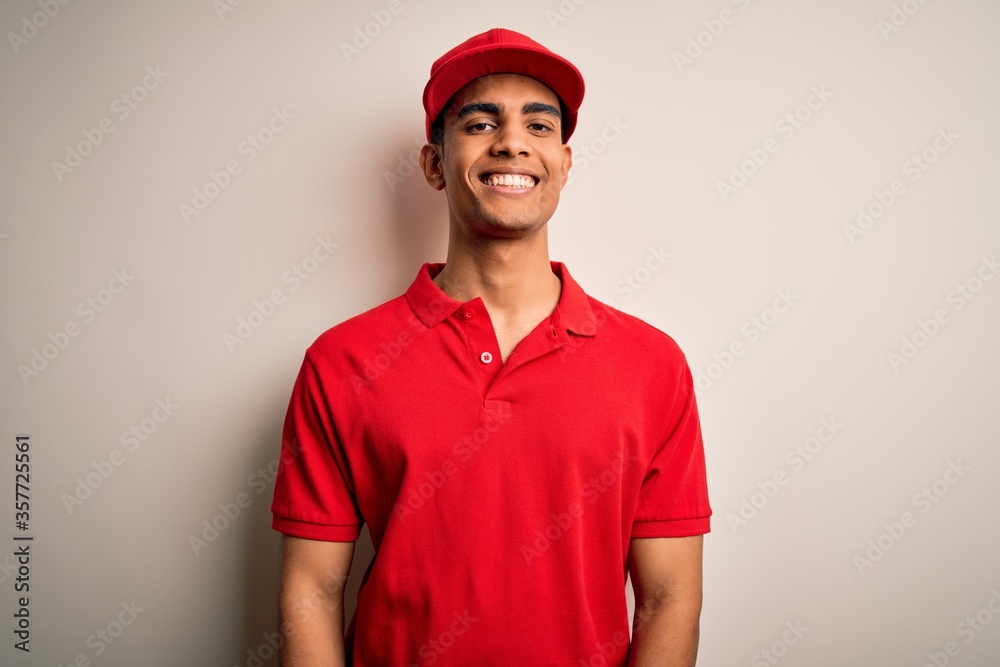 Young handsome african american man wearing casual polo and cap over red background with a happy and cool smile on face. Lucky person.