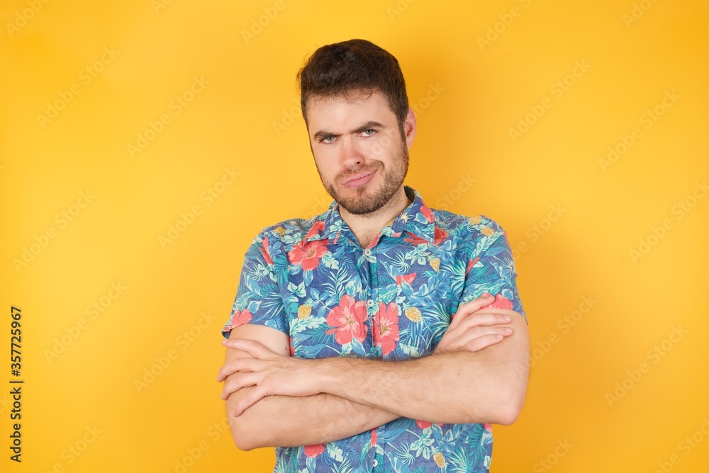 Picture of angry young Caucasian woman crossing arms standing isolated over background. Looking at camera.