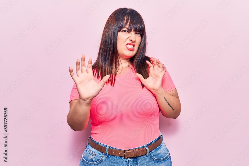 Young plus size woman wearing casual clothes afraid and terrified with fear expression stop gesture with hands, shouting in shock. panic concept. Young plus size woman wearing casual clothes afraid and terrified with fear expression stop gesture with hands, shouting in shock. panic concept.