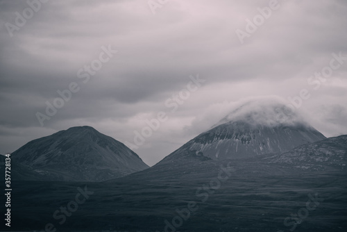 Panoramic view of the valley near the highest mountain peak of Paps of Jura (Beinn an Òir) under the dark storm sky. Dramatic clouds. Jura island, Inner Hebrides, Scotland, UK. Atmospheric landscape photo