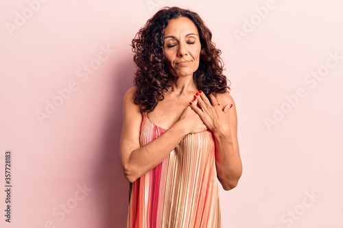 Middle age beautiful woman wearing casual t shirt smiling with hands on chest, eyes closed with grateful gesture on face. health concept.