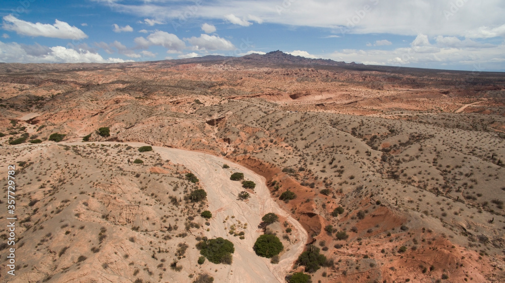 Fototapeta premium Aerial view of the arid desert and mountains with beautiful red colors and textures. 