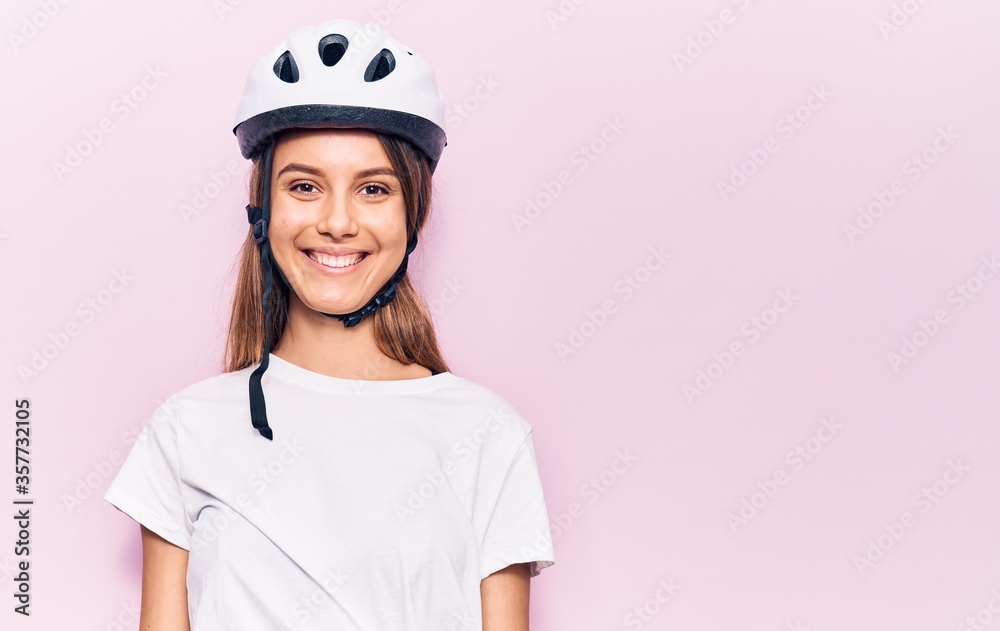 Young beautiful girl wearing bike helmet with a happy and cool smile on face. lucky person. Young beautiful girl wearing bike helmet with a happy and cool smile on face. lucky person.