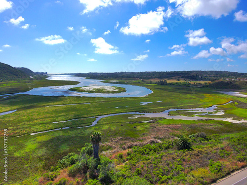 aerial shot of a gorgeous summer landscape at Batiquitos Lagoon with blue waters, lush green trees and blue sky background with clouds in Carlsbad California USA photo