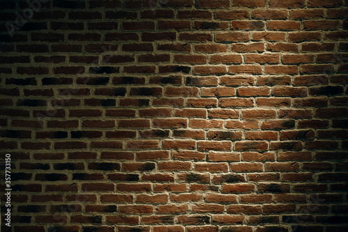 The texture of a brick wall with a light spot.