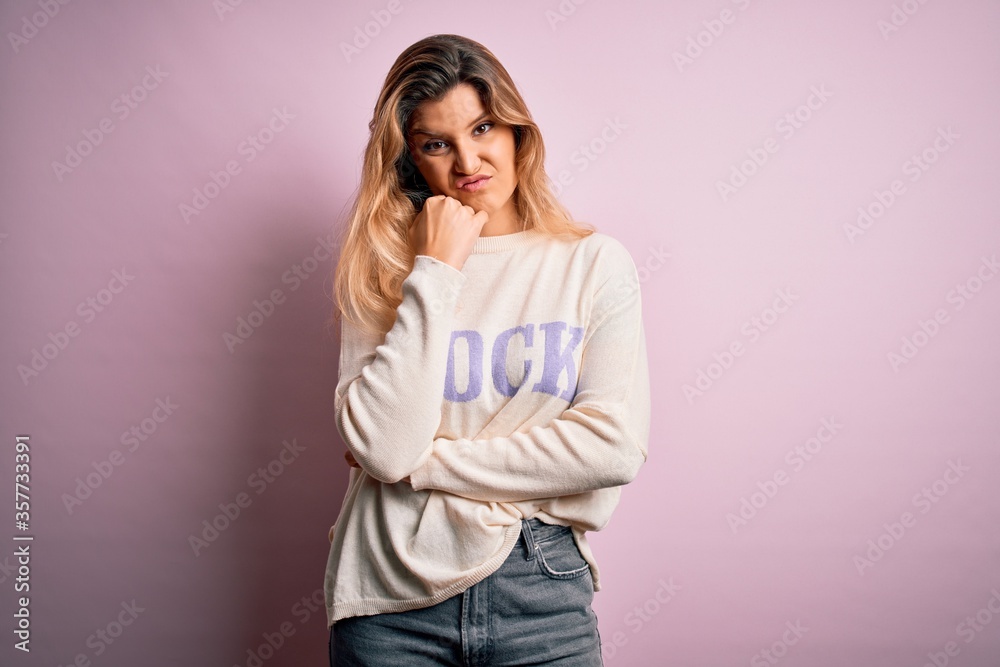 Young beautiful blonde woman wearing casual sweater standing over pink background thinking looking tired and bored with depression problems with crossed arms. Young beautiful blonde woman wearing casual sweater standing over pink background thinking looking tired and bored with depression problems with crossed arms.
