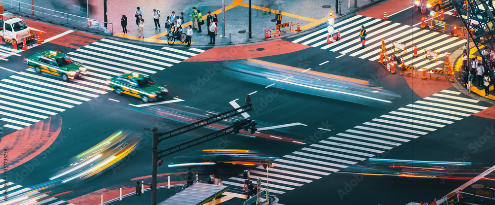 Fototapeta People and traffic cross the famous scramble intersection in Shibuya, Tokyo, Japan, one of the busiest crosswalks in the world