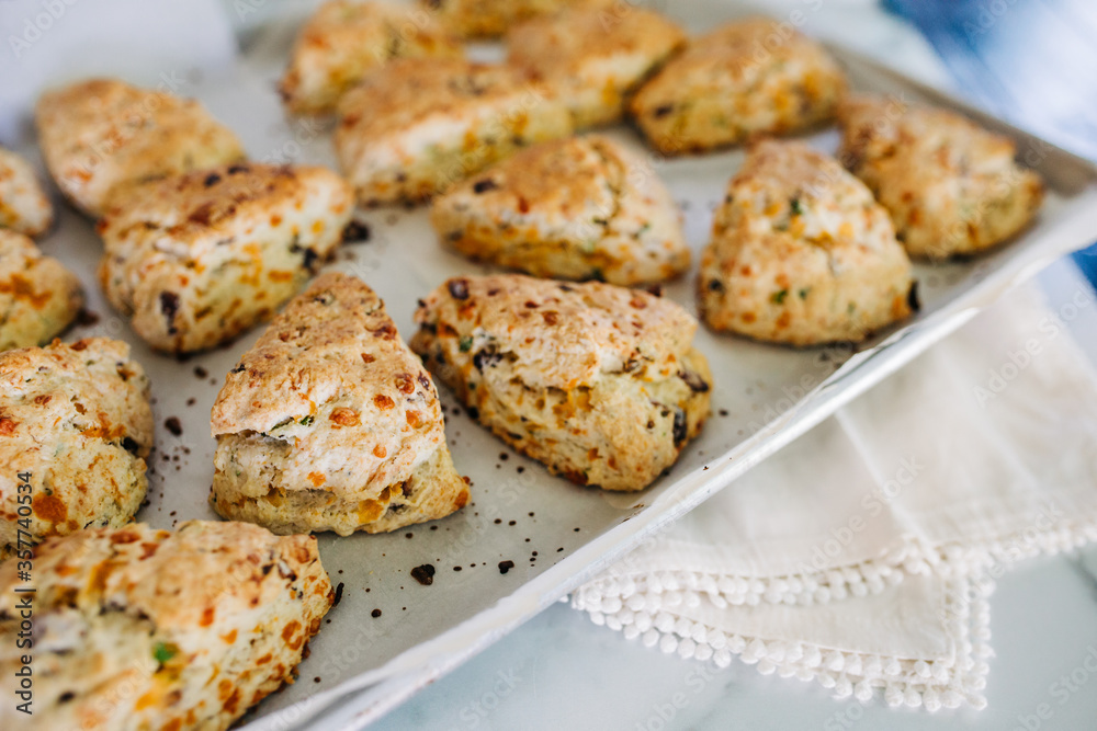 Bacon, cheddar and green onion scones on an aluminum baking sheet fresh out of the oven Bacon, cheddar and green onion scones on an aluminum baking sheet fresh out of the oven