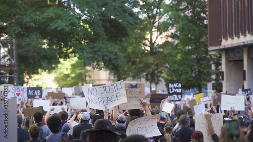 Protestors holding signs during a protest in city streets photo