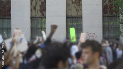 Protestors marching in city streets with signs photo