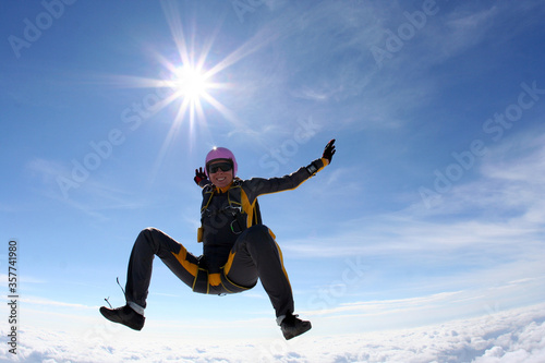 The girl parachutist performs figure freestyle in freefall.