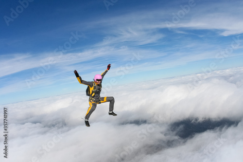 The girl parachutist performs figure freestyle in freefall.