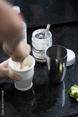 preparando uma caipirinha tipicamente  brasileira com limao, açucar e vodka juntamente com a coqueteleira