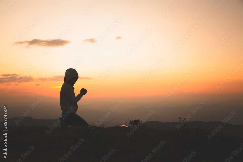 Obraz premium Woman praying in the morning on the sunrise background. Christianity concept. Pray background. Faith hope love concept.