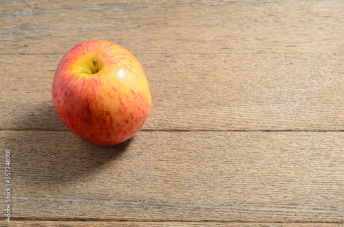 A ripe Apple against the background of textured dashboards is made in a rustic style. Selective focus.