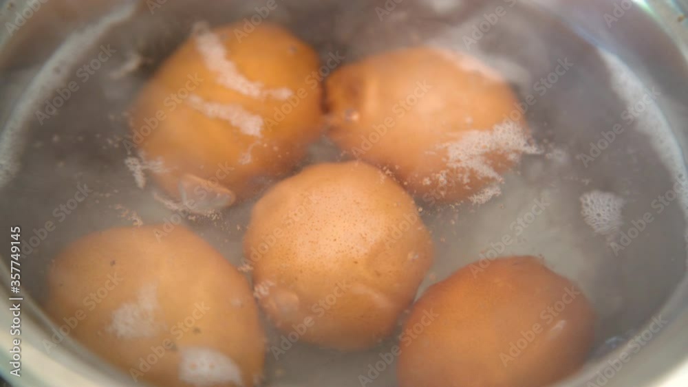 Close up of fresh farm eggs boiling in pot with hot water. Brown chicken egg for healthy breakfast Close up of fresh farm eggs boiling in pot with hot water. Brown chicken egg for healthy breakfast