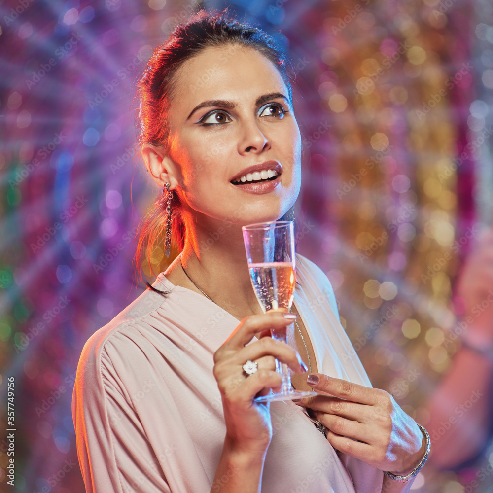 Portrait of attractive happy woman and her friends toasting with champagne