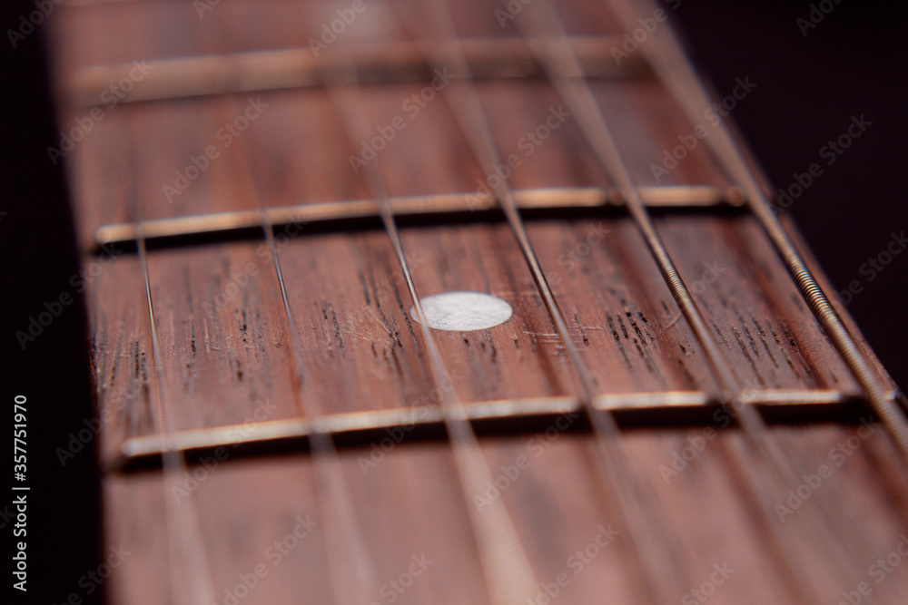 Macro photography to a six electric guitar strings and wooden fretboards. Vintage instruments and music concept Macro photography to a six electric guitar strings and wooden fretboards. Vintage instruments and music concept