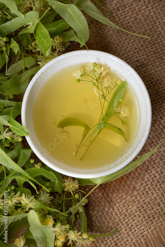Tea from linden. Fresh flowering linden on a wooden background. Healthy and natural tea. June linden harvest. Healthy.