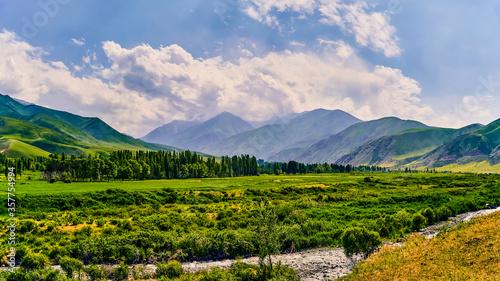 Panorama of a mountain valley in the summer. A fabulous mountain view of the peaks, amazing nature, summer in the mountains. Travel, tourism. beautiful background picture of nature