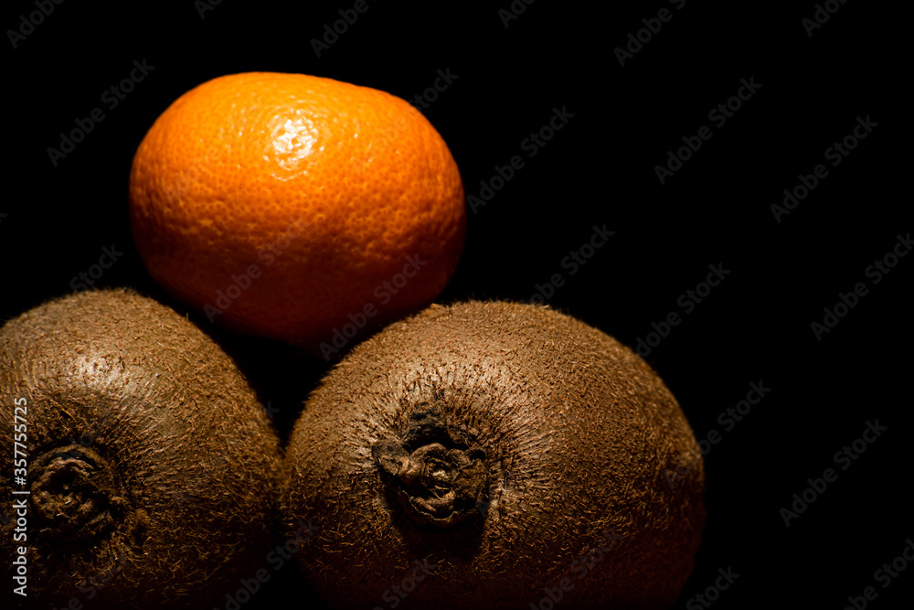 Mandarin with kiwi on a black background Mandarin with kiwi on a black background