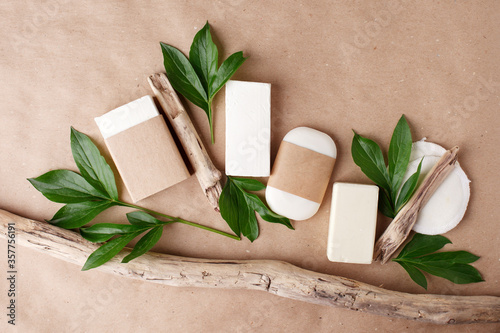 Zero waste natural cosmetics products on craft paper table. Flat lay, organic solid soap and shampoo bars, antibacterial handcrafted soap concept, mock up, organic detail, fern brunches photo