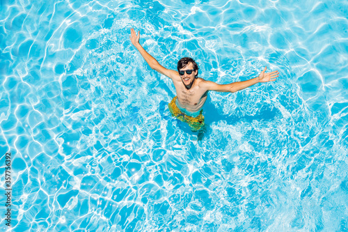 Young man swims in the pool  summer vacation concept