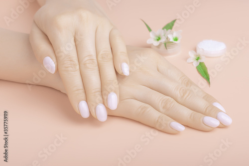 Beautiful hands with wild flowers on the table  anti-aging and anti-wrinkle cosmetics for hands. Skin care and beauty  skin hydration and Spa