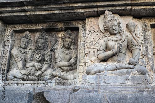 Wall carvings on stone at Prambanan hindu temples. Three sitting figures on lotus posture. Temples located close to the city of Yogyakarta, island of Java, Indonesia, Southeast Asia © Alba