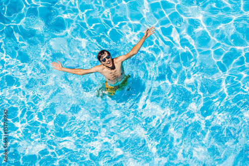 Young man swims in the pool, summer vacation concept
