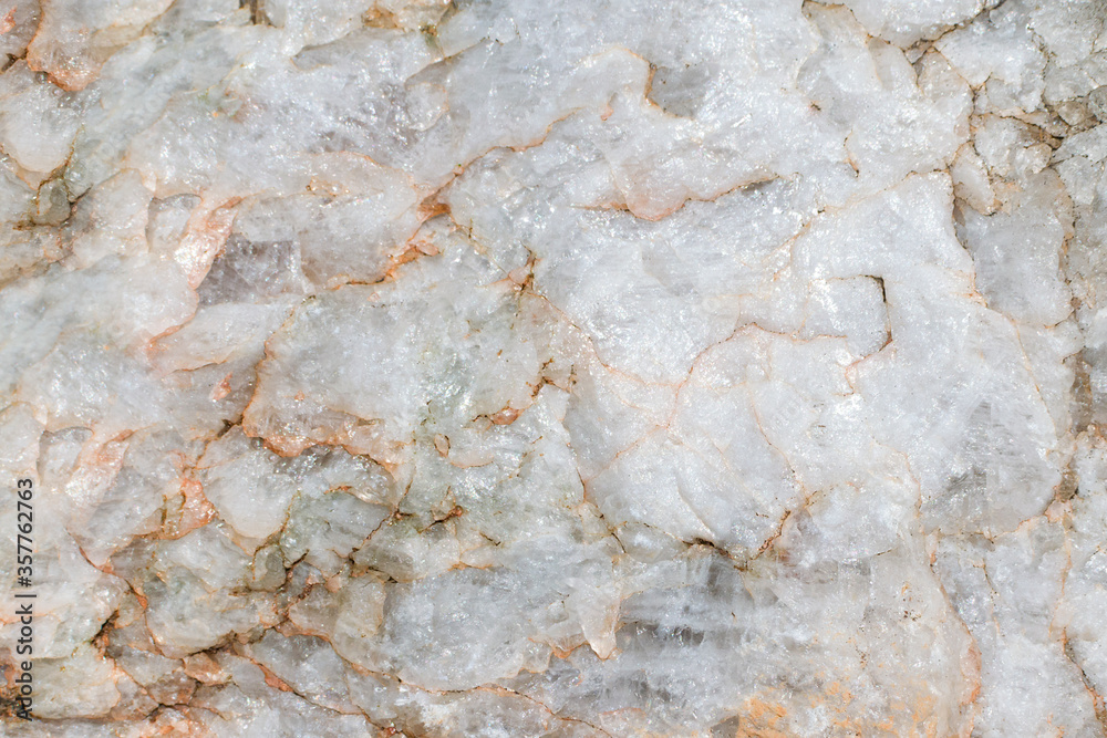 Light rough surface of marble with red stains. Closeup of raw stone, natural material, beautiful rock texture. Background.