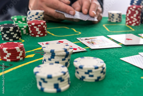 Male hand hold  chips and cards for poker on casino table