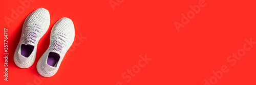 Sports sneakers on a red background. Сoncept of sport, fashion. Top view, flat lay. Banner.