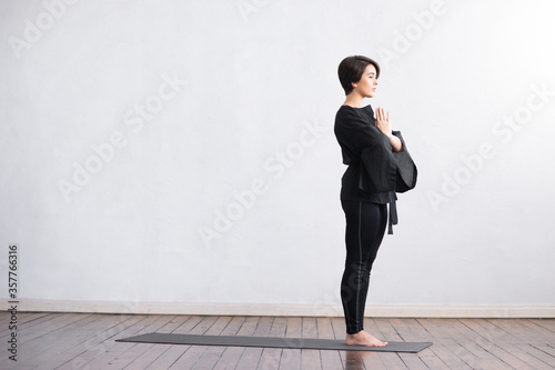 Young and fit woman practicing yoga indoor in the class. Stretching exercise in the day light. Sport  fitness  health care and lifestyle.