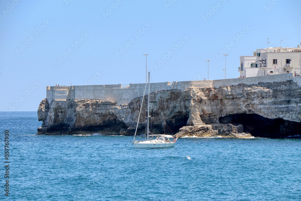 Sailboat in the azure sea on the coast of Polignano a Mare, Puglia, Italy Sailboat in the azure sea on the coast of Polignano a Mare, Puglia, Italy